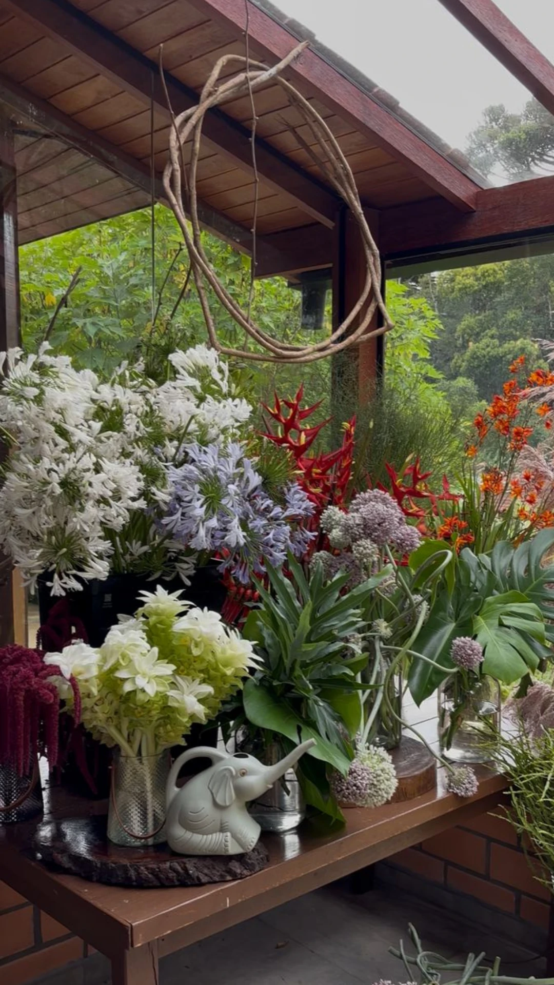 Mesa do ateliê cercada por flores da Bioma Tropical