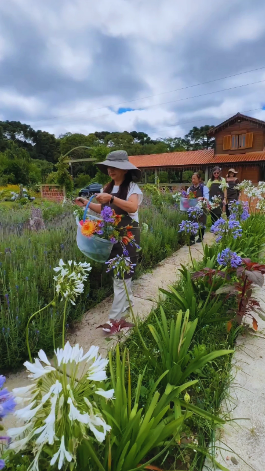 Participantes colhendo flores no jardim da Bioma Tropical